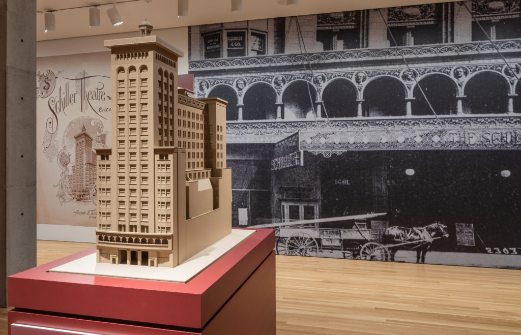 scale model of Garrick Theatre building displayed in front of large photo of Garrick Theatre facade