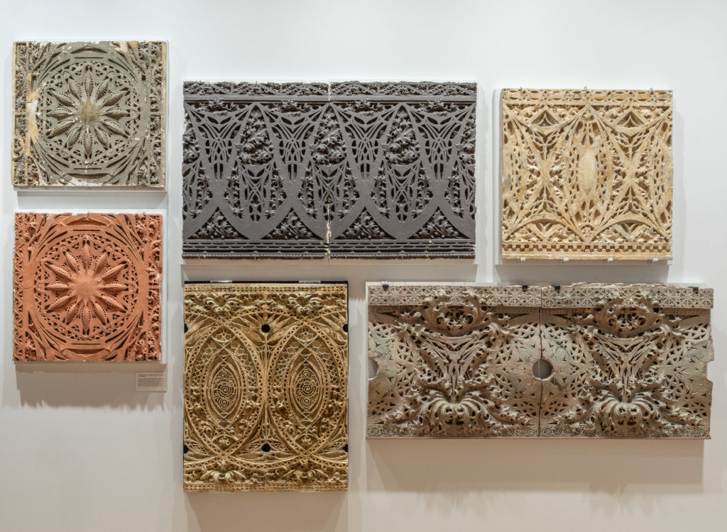 architectural ornamentation fragments displayed on gallery wall