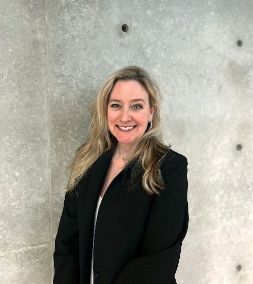 Mariah Keller smiling, standing in front of the distinctive design of the Tadao Ando wall.